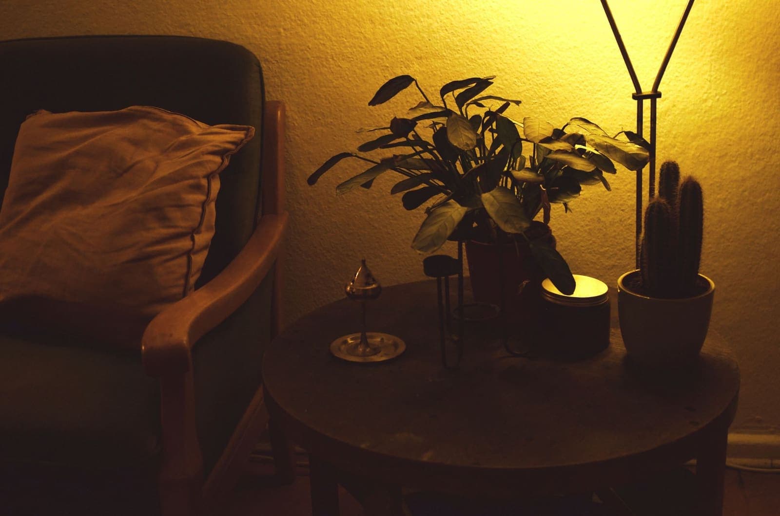 Schemerlamp naast een fauteuil in een woonkamer in de avond