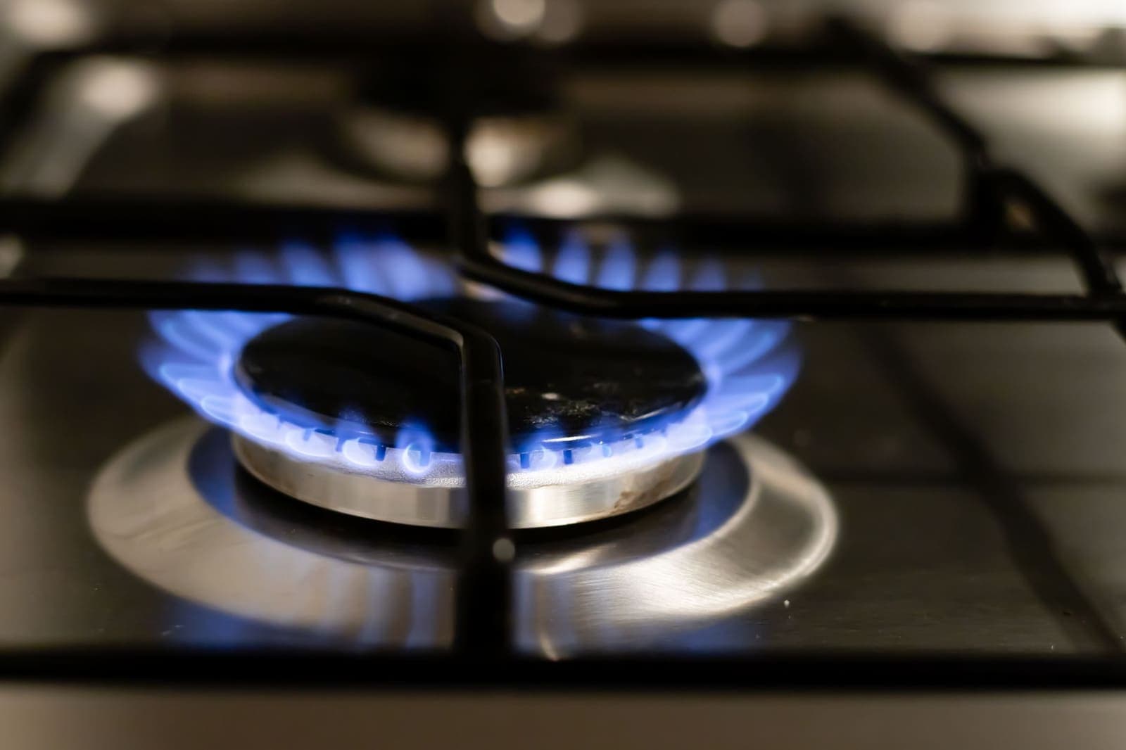 Blauwe vlam van een gaspit op een kookplaat