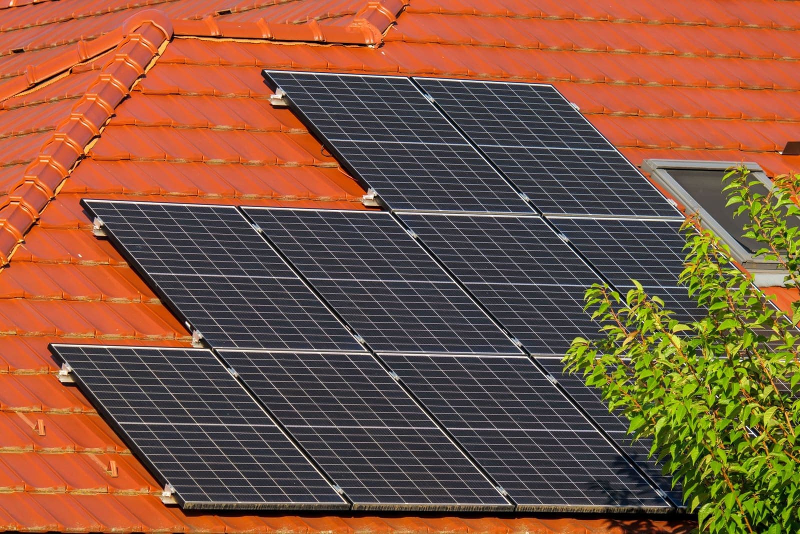 Zonnepanelen op het rode pannendak van een woonhuis